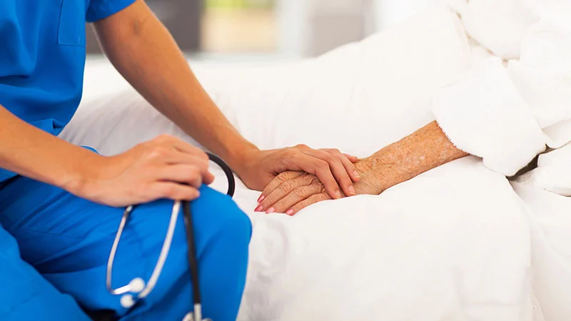 Pazuri Home Care - doctor holding an elder patients hand